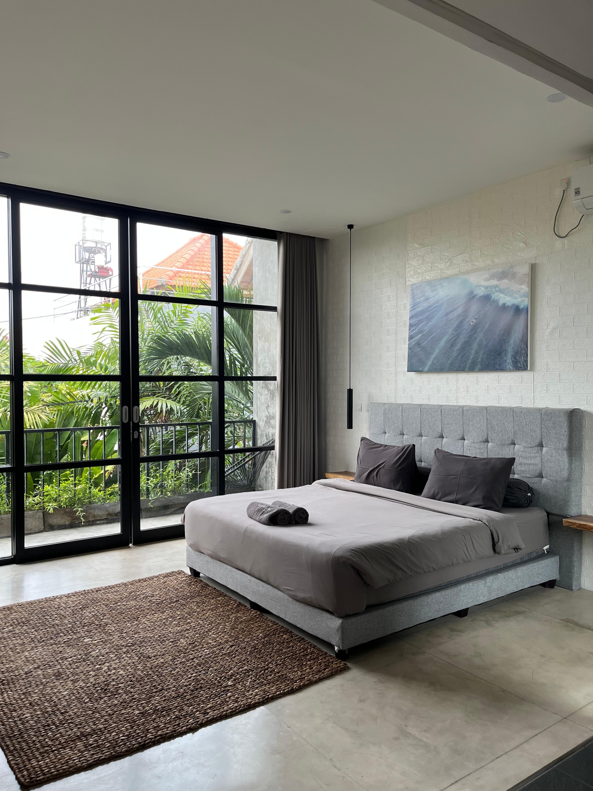Bright bedroom with floor-to-ceiling garden views.