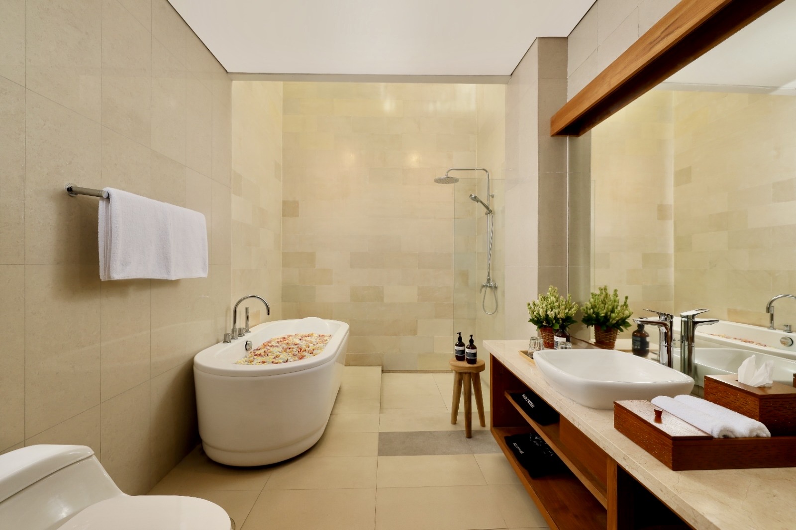 Ensuite bathroom with bathtube and flowers in the water for a romantic moment with your loved one.